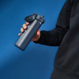 A dark gray water bottle stands upright with a flip-top lid and textured grip on a plain white background. Branding on the bottle reads ION8.