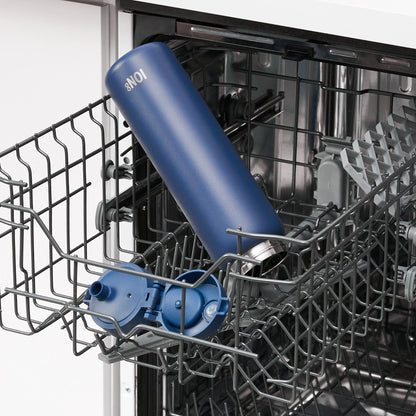 A blue insulated bottle labeled "8NO1" sits at an angle in the upper rack of an open dishwasher with its lid partially detached nearby.