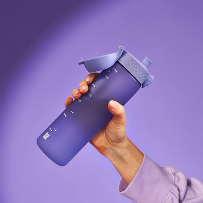 A hand holds a purple water bottle with a flip-top lid against a purple background. The bottle features measurement markings: 7-8, 9-10, 11-12, 1-2, 3-4, 5-6, 7-8 with a QR code at the bottom.