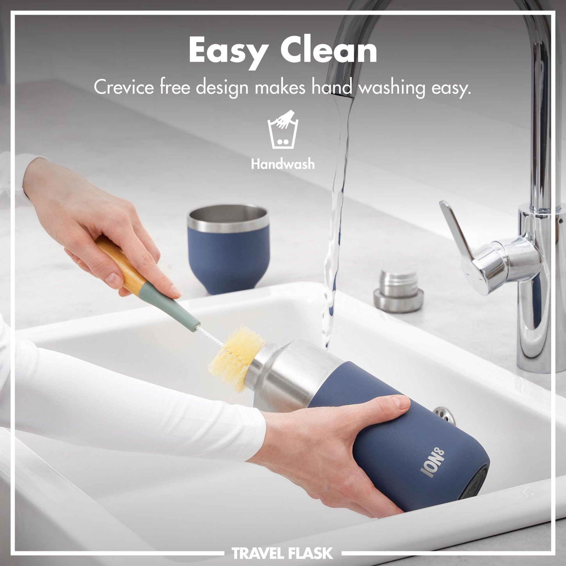 Person cleans travel flask with a brush under running water in a modern kitchen sink; text reads Easy Clean Crevice free design makes hand washing easy Handwash TRAVEL FLASK.