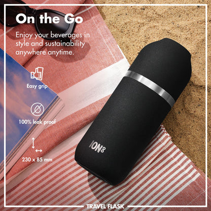 A black travel flask labeled "ION8" rests on a striped cloth by sand. Text reads "On the Go Enjoy your beverages in style and sustainability anywhere anytime Easy grip 100% leak proof 230 x 85 mm."